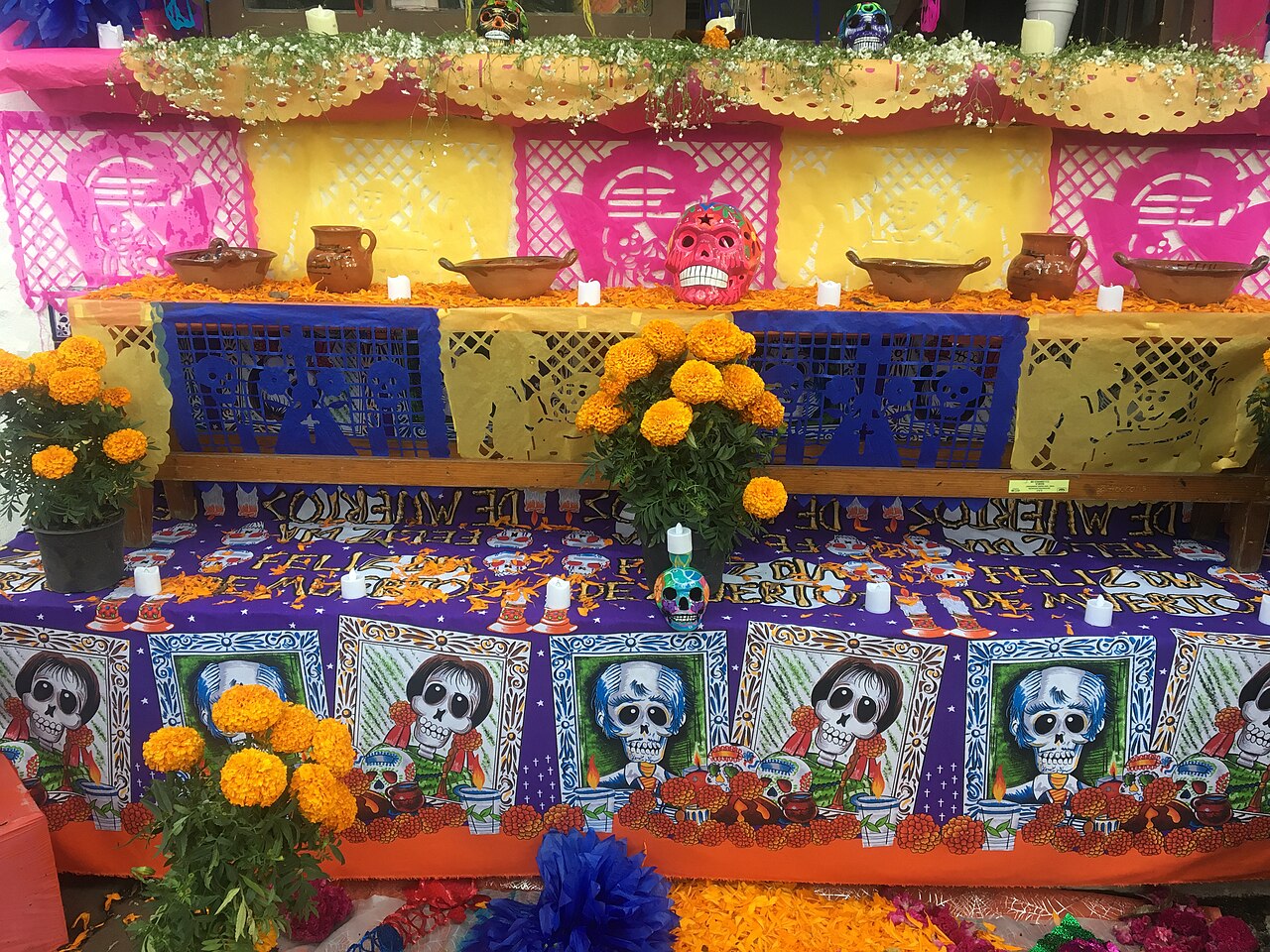 Altar de Día de Muertos con flores y papel picado